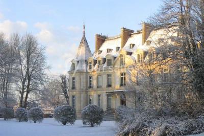 Façade d'un château éclairé par des lumières colorées, vue de nuit avec des silhouettes de personnes devant.