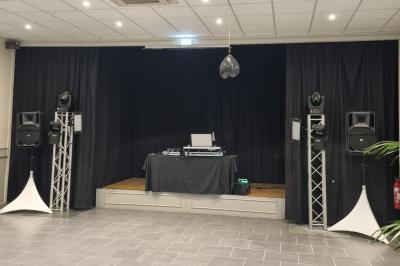 Miniature DJ Bondues (Nord) - Luk Event #4 Des personnes dansent et chantent dans une salle éclairée de lumières colorées, avec un chanteur au premier plan.