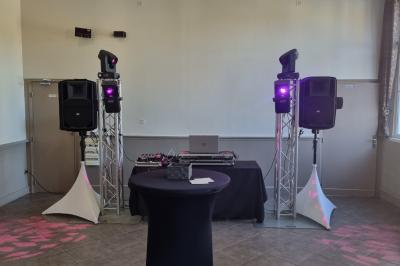 Miniature DJ Bondues (Nord) - Luk Event #6 Des personnes dansent et chantent dans une salle éclairée de lumières colorées, avec un chanteur au premier plan.