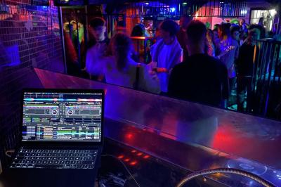 Miniature DJ Pau (Pyrénées-Atlantiques) - Dj Focoda Evenementiel #11 Table de mixage éclairée avec des lumières colorées, un ordinateur affichant un logiciel de DJ en arrière-plan.