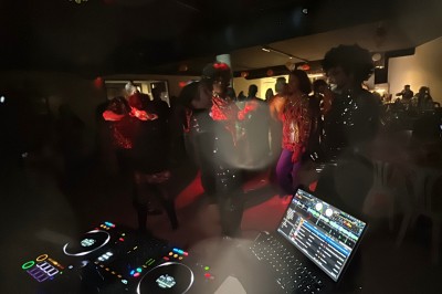 Miniature DJ Montpellier (Hérault) - DJ Manelya #21 Personnes dansant dans une ambiance festive avec des lumières colorées, vue depuis une table de mixage de DJ.