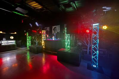 Miniature DJ Clohars-Fouesnant (Finistère) - Breizh Audio #3 Scène éclairée avec projecteurs colorés et écran central affichant des graphismes lumineux dans une ambiance sombre.