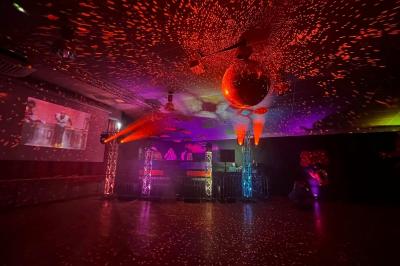 Miniature DJ Clohars-Fouesnant (Finistère) - Breizh Audio #5 Scène éclairée avec projecteurs colorés et écran central affichant des graphismes lumineux dans une ambiance sombre.