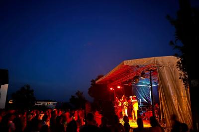 Miniature DJ Clohars-Fouesnant (Finistère) - Breizh Audio #6 Scène éclairée avec projecteurs colorés et écran central affichant des graphismes lumineux dans une ambiance sombre.