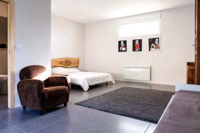 Pelouse verdoyante entourée de grands arbres sous un ciel partiellement nuageux.