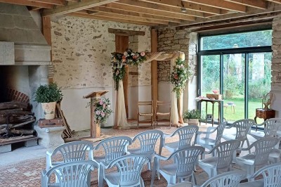 Pelouse verdoyante entourée de grands arbres sous un ciel partiellement nuageux.