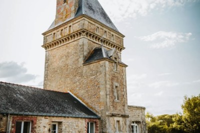 Pelouse verdoyante entourée de grands arbres sous un ciel partiellement nuageux.