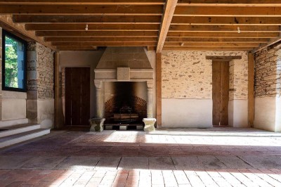 Pelouse verdoyante entourée de grands arbres sous un ciel partiellement nuageux.