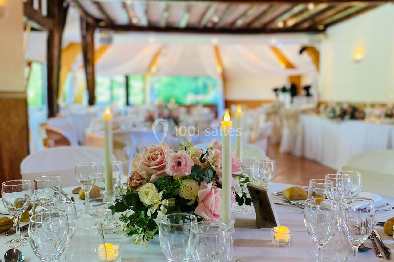 Location salle Saint-Léger-en-Bray (Oise) - Domaine du Colombier #16 Table élégamment dressée avec des fleurs, bougies et vaisselle raffinée dans une salle de réception lumineuse.