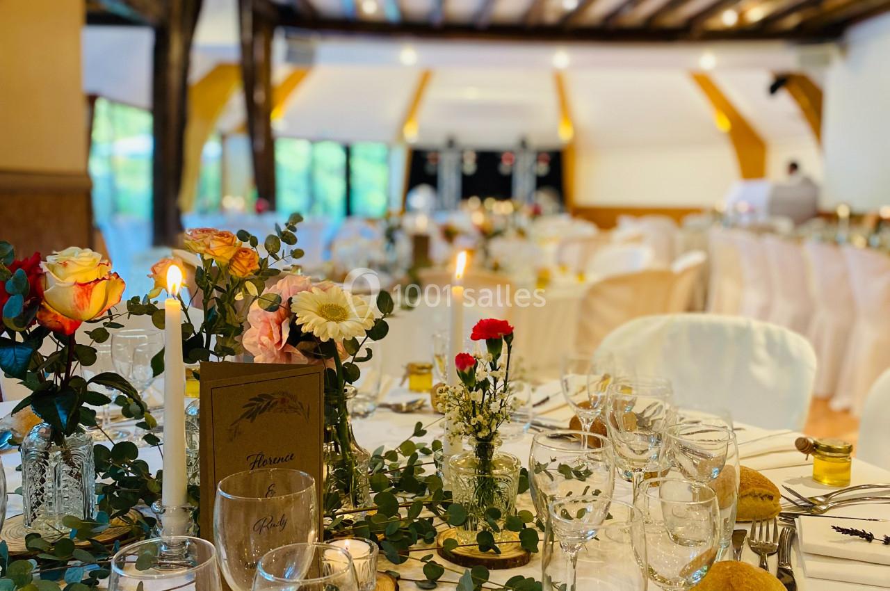 Location salle Saint-Léger-en-Bray (Oise) - Domaine du Colombier #19 Salle de réception décorée avec des tables dressées, ornées de fleurs, bougies et vaisselle élégante.