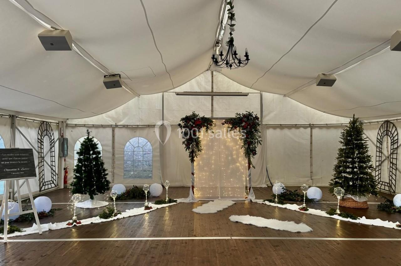 Location salle Saint-Léger-en-Bray (Oise) - Domaine du Colombier #21 Décoration festive sous une tente avec arche lumineuse, sapins de Noël, guirlandes et sol en bois.