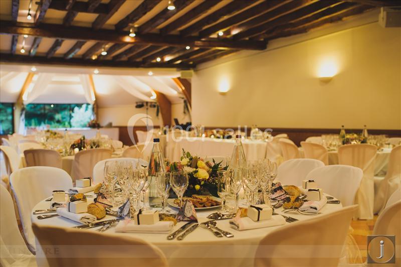 Location salle Saint-Léger-en-Bray (Oise) - Domaine du Colombier #4 Salle de réception décorée avec des tables rondes dressées, nappes blanches, bouquets et couverts élégants.