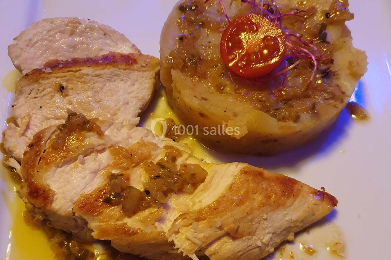 Assiette avec filet de poulet rôti, écrasé de pommes de terre aux herbes et tomate cerise en garniture.