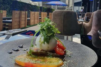 Miniature Location salle Paris 15 (Paris) - Tout Le Monde En Parle Montparnasse #21 Planche de charcuterie et fromages sur une table en terrasse, avec une bouteille de vin blanc dans un seau à glace.