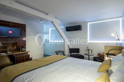 Comptoir de réception en bois avec étagères éclairées contenant des bouteilles et des verres, décoré de plantes séchées.