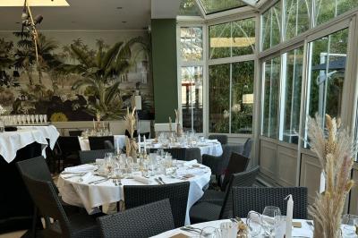 Comptoir de réception en bois avec étagères éclairées contenant des bouteilles et des verres, décoré de plantes séchées.