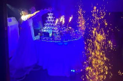 Miniature DJ Bannalec (Finistère) - Big Up Anim #8 Scène décorée avec guirlandes lumineuses, plantes et une table de DJ éclairée en bleu et blanc.