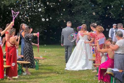 Miniature DJ Bannalec (Finistère) - Big Up Anim #15 Scène décorée avec guirlandes lumineuses, plantes et une table de DJ éclairée en bleu et blanc.