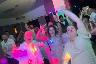 Miniature DJ Bannalec (Finistère) - Big Up Anim #16 Scène décorée avec guirlandes lumineuses, plantes et une table de DJ éclairée en bleu et blanc.