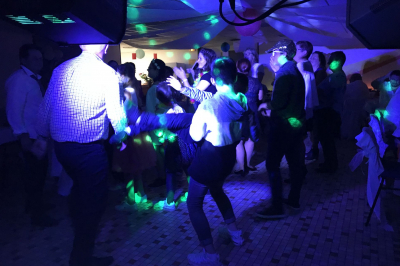Stand de DJ avec éclairage LED rouge et vert, installé dans une salle avec décoration intérieure et lumière naturelle.