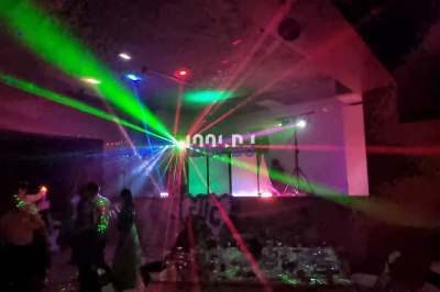 Miniature DJ Diémoz (Isère) - FeeJoliEvents #7 Salle sombre avec des jeux de lumières colorées et des personnes dansant sous des faisceaux laser.