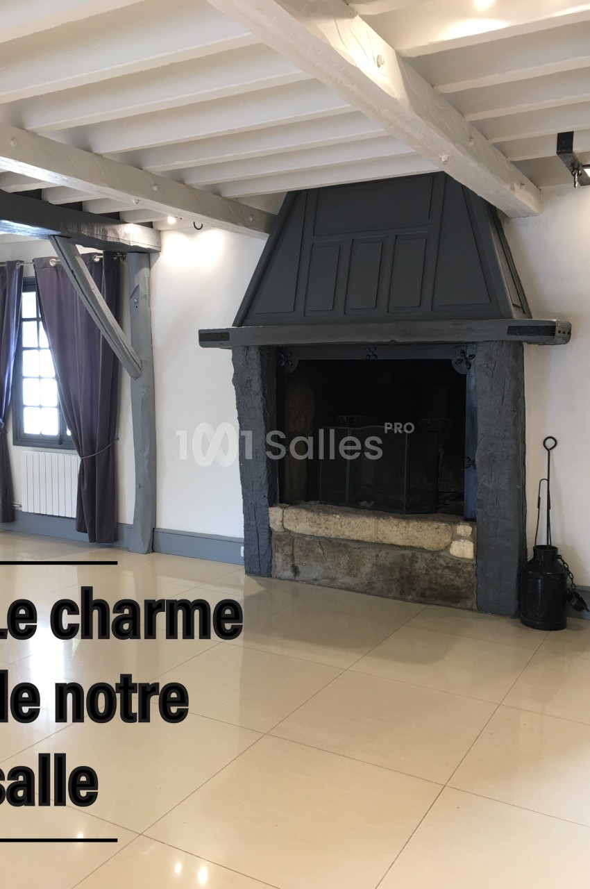 Cheminée en pierre et bois dans une salle lumineuse avec poutres apparentes et rideaux violets.