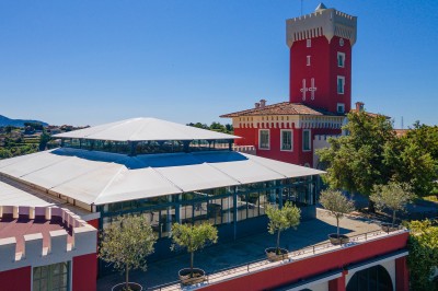 Espace lumineux avec tables hautes, affiches de mode et personnes discutant sous une structure métallique.