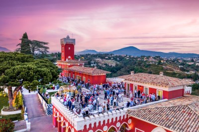 Espace lumineux avec tables hautes, affiches de mode et personnes discutant sous une structure métallique.