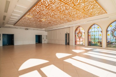 Espace lumineux avec tables hautes, affiches de mode et personnes discutant sous une structure métallique.