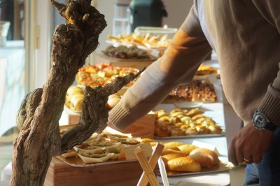 Espace lumineux avec tables hautes, affiches de mode et personnes discutant sous une structure métallique.