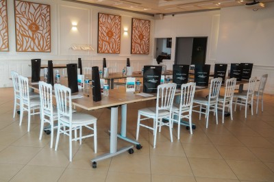 Espace lumineux avec tables hautes, affiches de mode et personnes discutant sous une structure métallique.