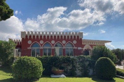 Espace lumineux avec tables hautes, affiches de mode et personnes discutant sous une structure métallique.