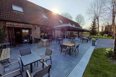 Miniature Location salle Mouscron (Hainaut) - Le Belvédère #23 Terrasse extérieure d'un restaurant avec des tables et chaises sur un sol en pierre, entourée de verdure et arbres.