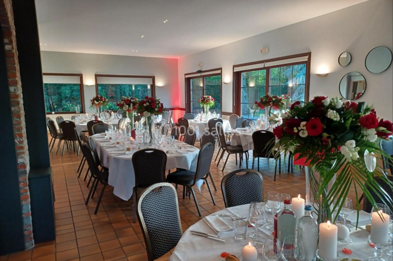 Location salle Mouscron (Hainaut) - Le Belvédère #16 Salle de réception décorée avec des tables rondes dressées, ornées de bouquets de fleurs rouges et blanches.