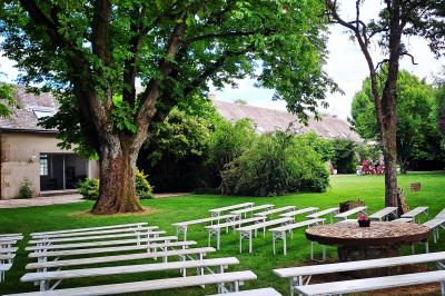 Miniature Location salle Villampuy (Eure-et-Loir) - Domaine de la Rainville #32 Salle de réception décorée avec des tables dressées, des guirlandes lumineuses et des arrangements floraux.