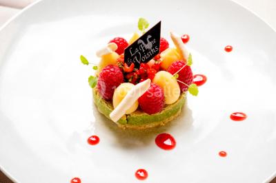 Miniature Location salle Voisins-le-Bretonneux (Yvelines) - La Ferme de Voisins #29 Table dressée avec des verres, couverts et serviettes, entourée de chaises colorées dans une salle lumineuse avec…