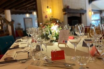 Miniature Location salle Voisins-le-Bretonneux (Yvelines) - La Ferme de Voisins #4 Table dressée avec des verres, couverts et serviettes, entourée de chaises colorées dans une salle lumineuse avec…