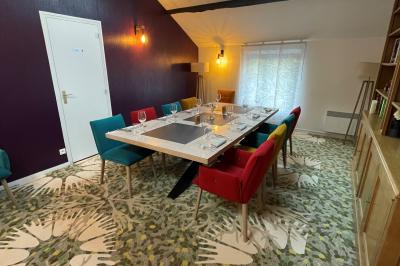 Miniature Location salle Voisins-le-Bretonneux (Yvelines) - La Ferme de Voisins #21 Table dressée avec des verres, couverts et serviettes, entourée de chaises colorées dans une salle lumineuse avec…