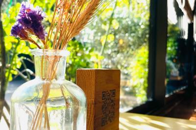 Miniature Location salle Voisins-le-Bretonneux (Yvelines) - La Ferme de Voisins #12 Table dressée avec des verres, couverts et serviettes, entourée de chaises colorées dans une salle lumineuse avec…