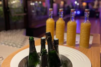 Miniature Location salle Voisins-le-Bretonneux (Yvelines) - La Ferme de Voisins #13 Table dressée avec des verres, couverts et serviettes, entourée de chaises colorées dans une salle lumineuse avec…