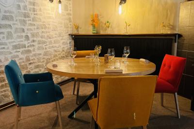 Miniature Location salle Voisins-le-Bretonneux (Yvelines) - La Ferme de Voisins #18 Table dressée avec des verres, couverts et serviettes, entourée de chaises colorées dans une salle lumineuse avec…