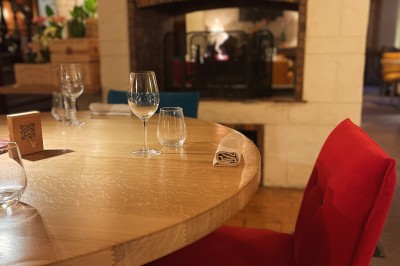 Miniature Location salle Voisins-le-Bretonneux (Yvelines) - La Ferme de Voisins #33 Table dressée avec des verres, couverts et serviettes, entourée de chaises colorées dans une salle lumineuse avec…