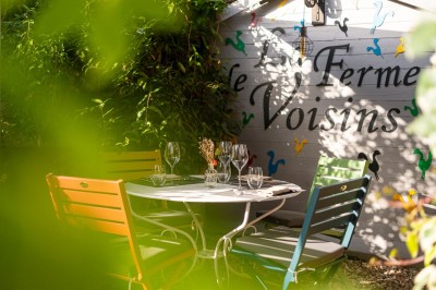 Miniature Location salle Voisins-le-Bretonneux (Yvelines) - La Ferme de Voisins #34 Table dressée avec des verres, couverts et serviettes, entourée de chaises colorées dans une salle lumineuse avec…