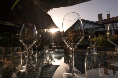 Miniature Location salle Voisins-le-Bretonneux (Yvelines) - La Ferme de Voisins #35 Table dressée avec des verres, couverts et serviettes, entourée de chaises colorées dans une salle lumineuse avec…