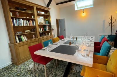 Miniature Location salle Voisins-le-Bretonneux (Yvelines) - La Ferme de Voisins #40 Table dressée avec des verres, couverts et serviettes, entourée de chaises colorées dans une salle lumineuse avec…