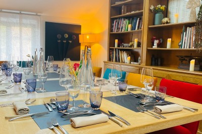 Miniature Location salle Voisins-le-Bretonneux (Yvelines) - La Ferme de Voisins #43 Table dressée avec des verres, couverts et serviettes, entourée de chaises colorées dans une salle lumineuse avec…