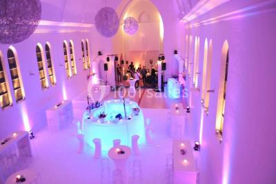 Miniature Location salle Tournai (Hainaut) - Domaine Domremy #3 Salle de réception lumineuse avec bar central circulaire, tables hautes et éclairage coloré.