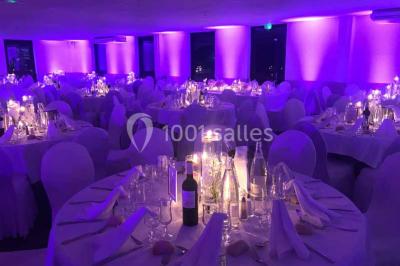 Une mariée lance son bouquet à un groupe de femmes rassemblées dans un jardin lors d'une réception en soirée.