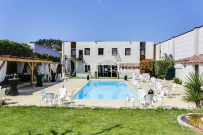 Une mariée lance son bouquet à un groupe de femmes rassemblées dans un jardin lors d'une réception en soirée.