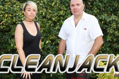 Miniature DJ Pézilla-la-Rivière (Pyrénées-Orientales) - Cleanjack #3 Un duo musical se produit sur une scène intérieure avec guitare et chant, devant un public assis.